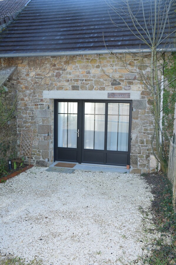 A stone building with a black door and a sign above it.