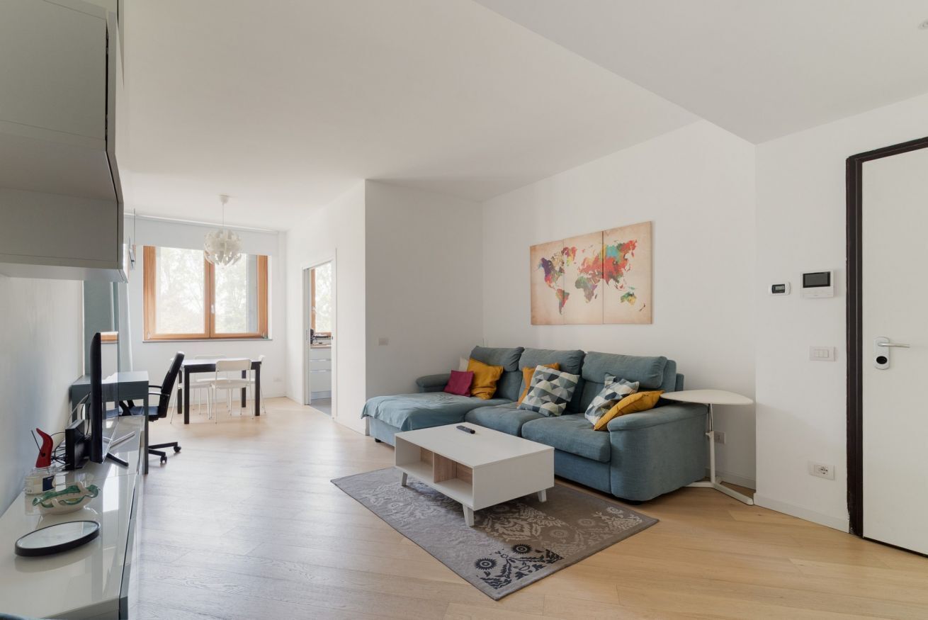 A modern living room with a sofa, coffee table, and a world map painting.