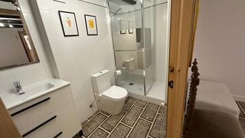 A bathroom with a toilet, sink, and shower.