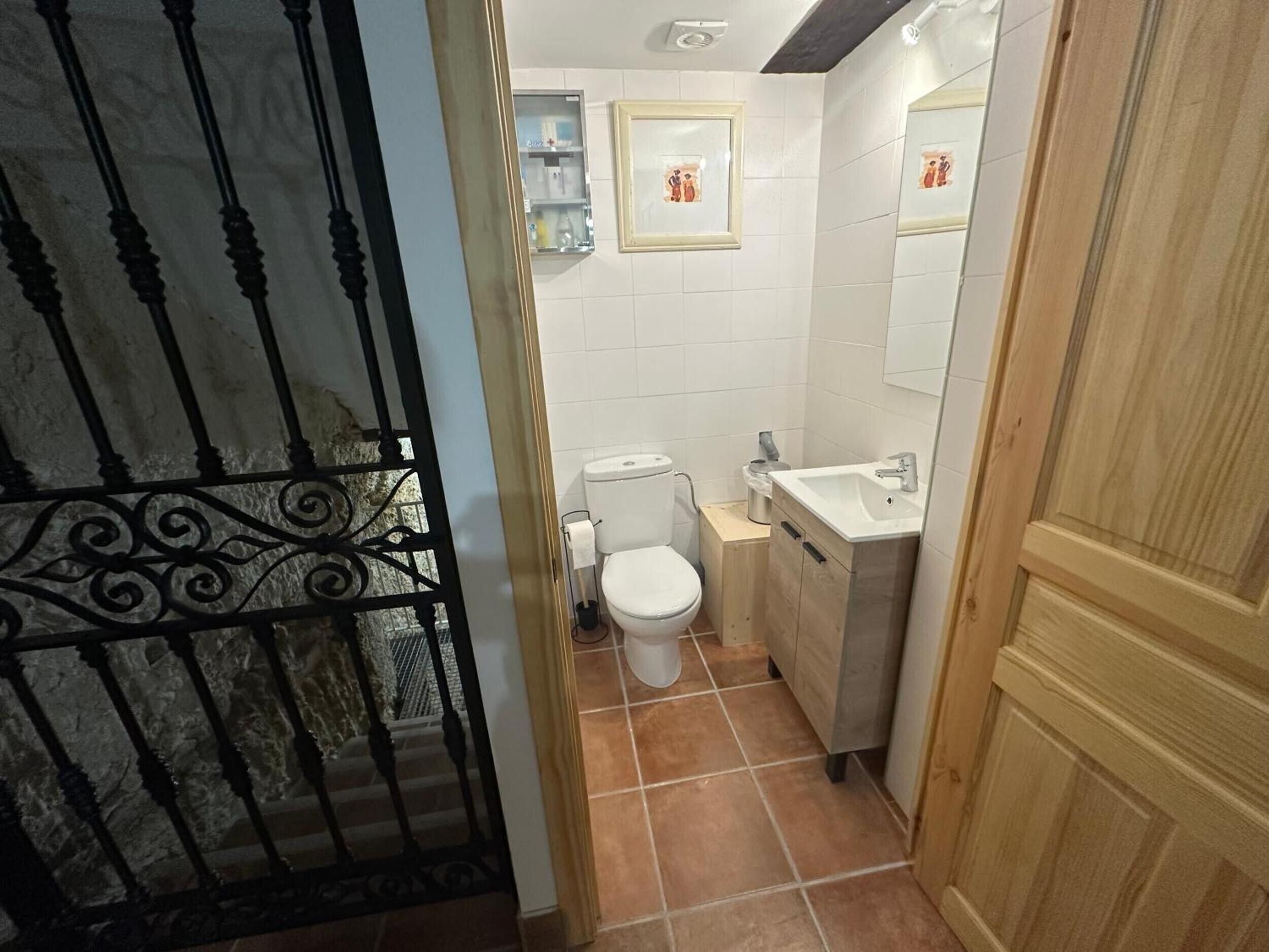 A bathroom with a toilet, sink, and a mirror.