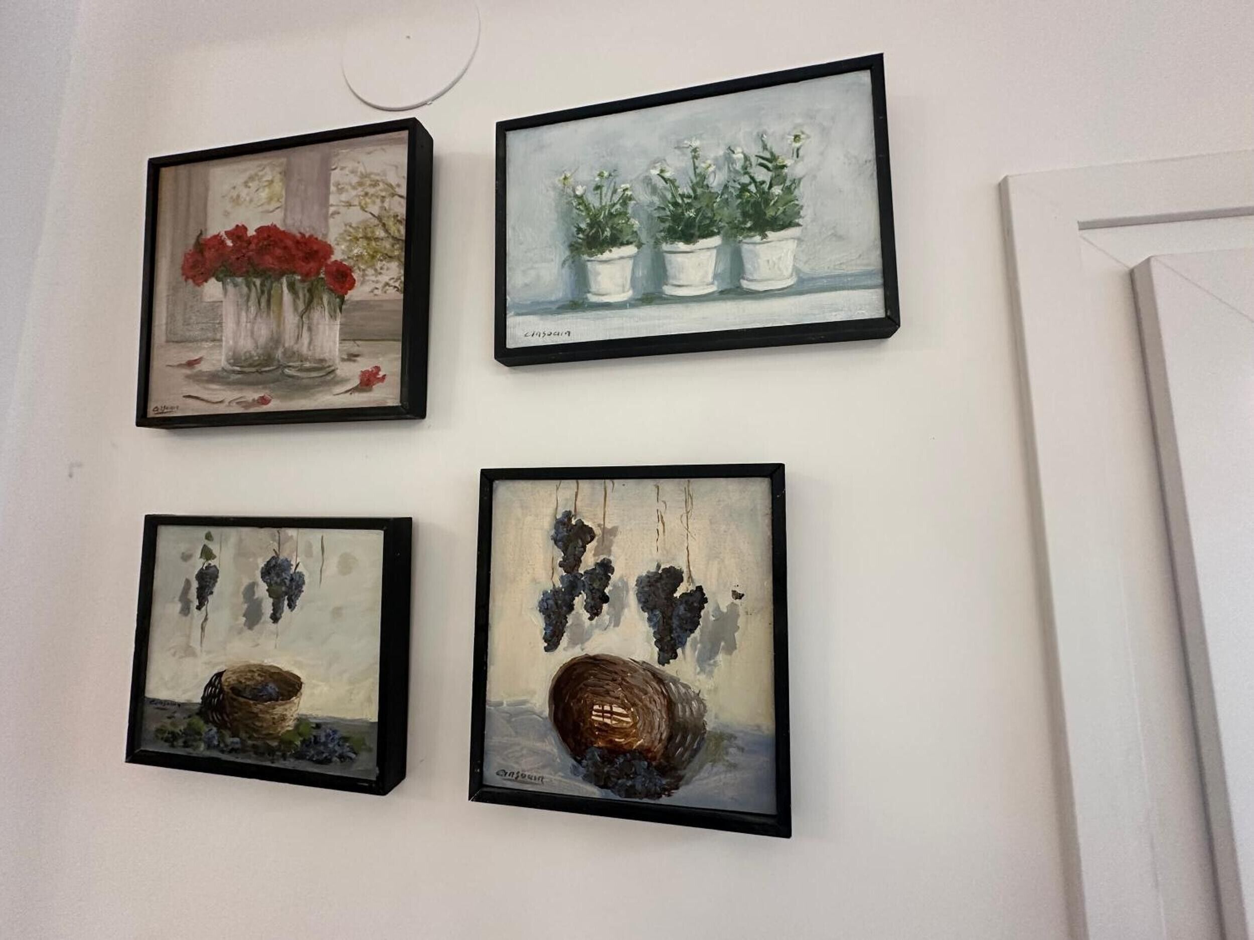 Four framed artworks on a wall.