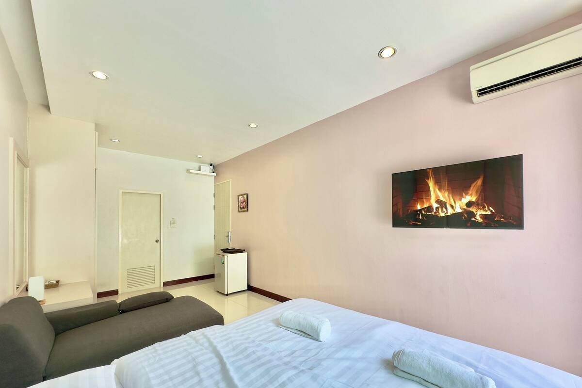 Ein Hotelzimmer mit Bett, Sofa, Kamin und Klimaanlage.