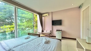 Habitación de hotel con dos camas, una silla, un televisor y un minibar.