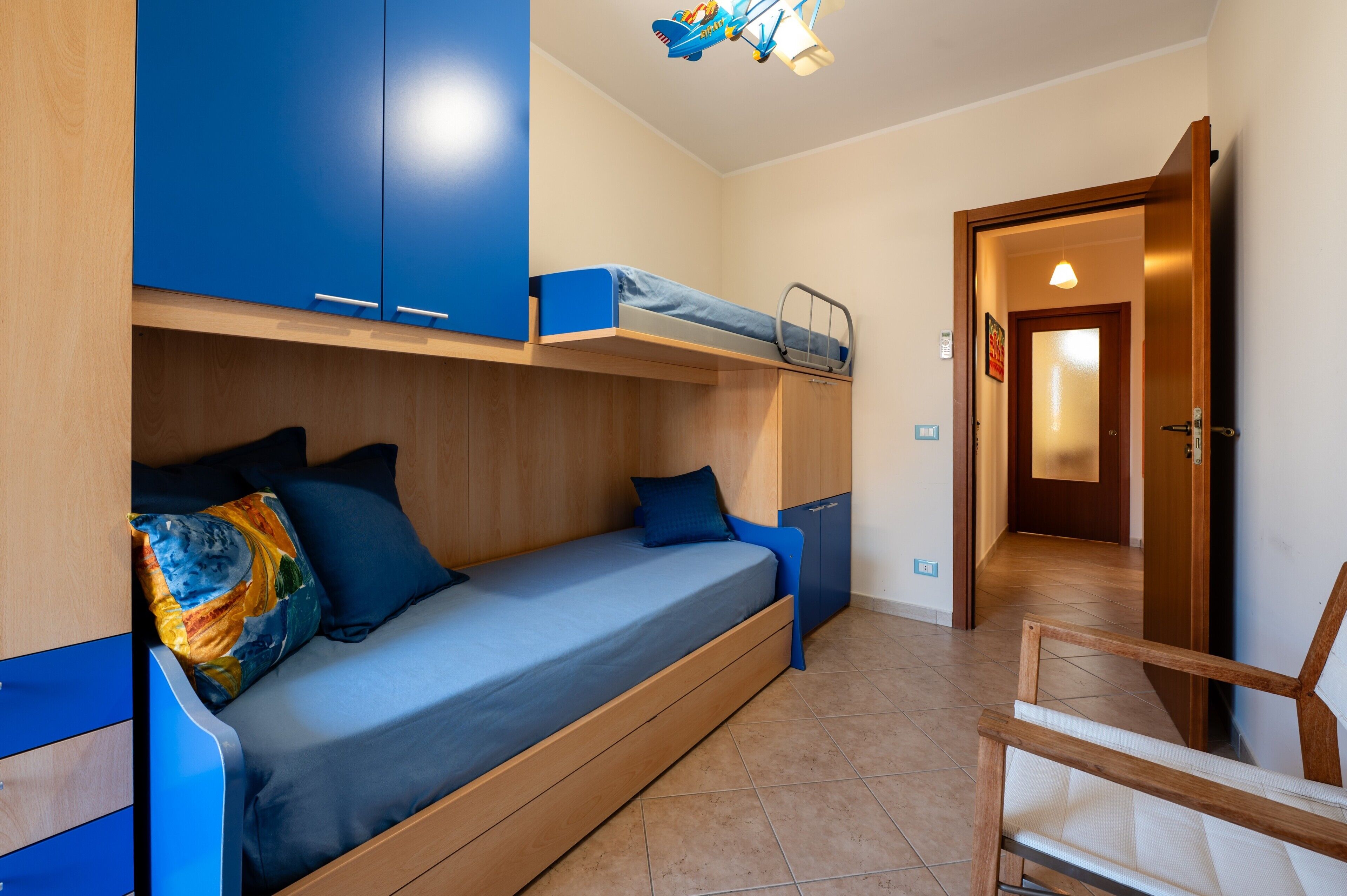Une chambre avec un lit superposé, un bureau et une chaise.