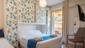 Une chambre d’hôtel avec un lit, une chaise, une armoire et une vue sur l’extérieur.