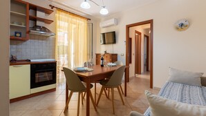 Un espace de vie compact comprenant une cuisine, un coin repas et un petit coin salon.