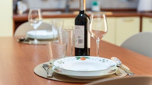 Une table à manger dressée avec une assiette, des verres à vin et une bouteille de vin.