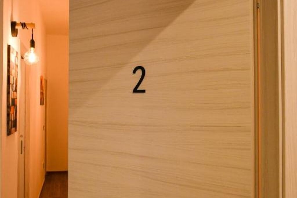 Un couloir avec un mur en bois et le chiffre « 2 » indiquant le numéro de la pièce.