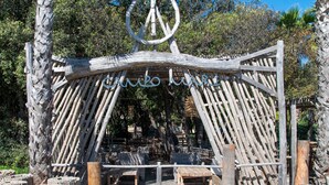 A wooden structure with a circular emblem at the top, surrounded by seating areas. - Apartment '4 Personne' with Shared Pool, Wi-Fi and Air Conditioning (Cervione)