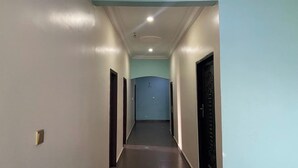 A long, narrow hallway with light blue walls and a dark floor.