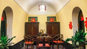 A traditional dining room with a high ceiling, two wooden cabinets, a chandelier, and red decorations on the walls. - yunzhikeshepingyaoguchengxianyadian (Jinzhong)