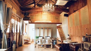 A spacious loft-style room with a high ceiling, wooden beams, a chandelier, and a loft bed. - yunzhikeshepingyaoguchengxianyadian (Jinzhong)