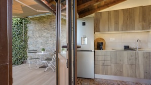 A modern kitchen with wooden cabinets, a built-in oven, and a small refrigerator.