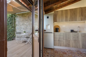 A modern kitchen with wooden cabinets, a built-in oven, and a small refrigerator.
