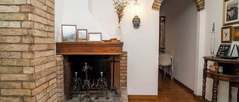 A fireplace with a brick surround, a wooden mantel, and a decorative candelabra.
