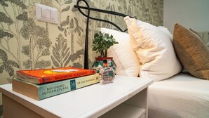 A bedside table with books, a small potted plant, and a perfume bottle. - Charming Tuscany style home with AC and heater in beautiful Umbria. (Umbria)