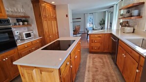 Een moderne keuken met houten kastjes, een centraal eiland en een ingebouwde magnetron.
