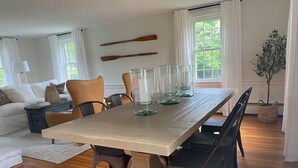 Een eetgedeelte met een houten tafel, stoelen en glazen.