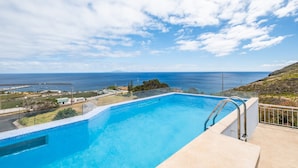 Una piscina con vista al océano y un cielo despejado.