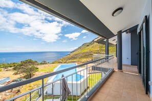 A balcony with a view of the sea and a swimming pool. - Villa Eastern Edge by Homie (Machico)