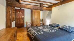 A bedroom with a wooden bed, a wooden wardrobe, a wooden desk, and a wooden chair. - Cottage in a Charming Shepherd’s House, Vast Private Land in the Heart of the Pyrenees (CASTET)