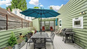 A patio with a table and chairs, a grill, and planters. - QAnne Hideaway•PrivateDeck•Jacuzzi Tub•CA King•BBQ (Seattle)