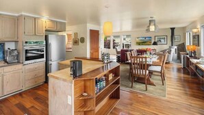 A spacious kitchen with wooden cabinets, a built-in oven, and a large island with a coffee machine. - QAnne Hideaway•PrivateDeck•Jacuzzi Tub•CA King•BBQ (Seattle)