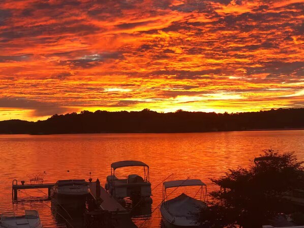 Ein Sonnenuntergang über einem See mit Booten an der Anlegestelle.