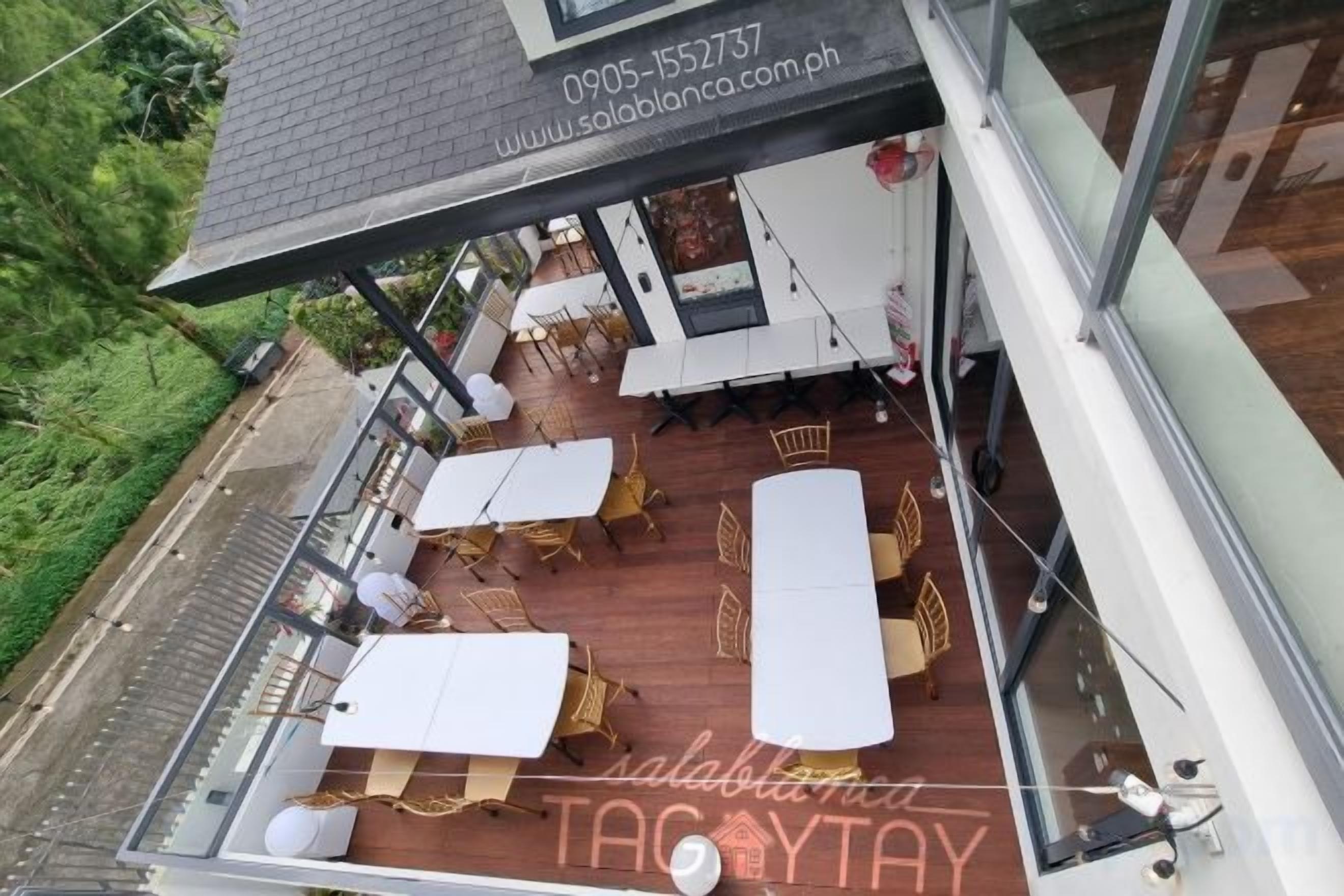 A rooftop terrace with outdoor seating and a glass railing.
