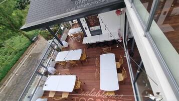 A rooftop terrace with outdoor seating and a glass railing.