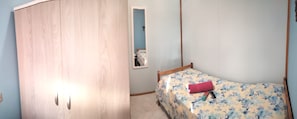 A bedroom with a bed, a wardrobe, and a small window.