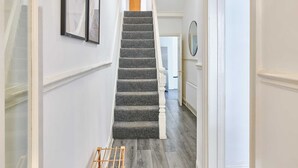 A staircase with a grey carpet, white walls, and a wooden door at the top. - Host Stay Bishop House (Liverpool)