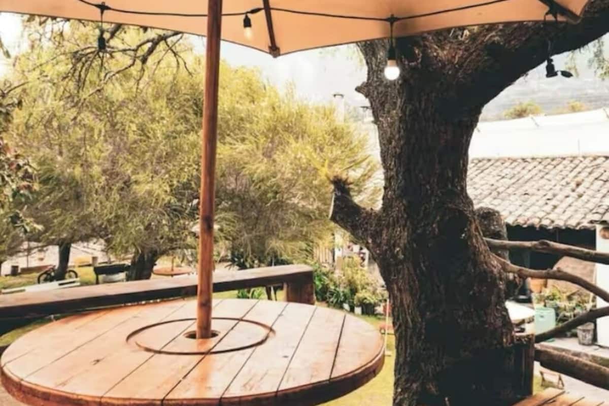 A wooden deck with a round table and a large umbrella.