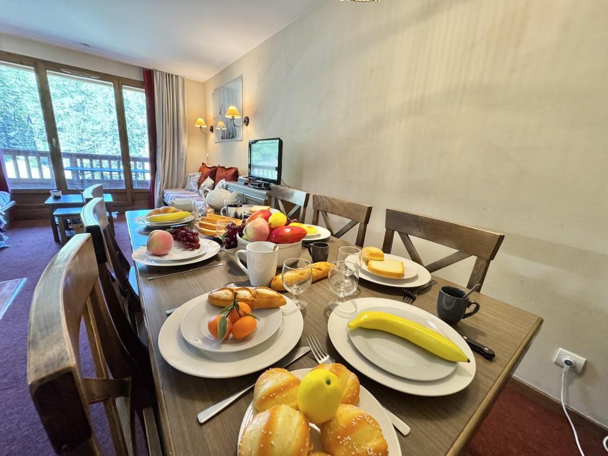 A dining table set with breakfast items including fruits, pastries, and beverages.