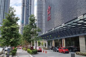 Un edificio moderno con una gran pantalla digital y un área de acceso cubierta.