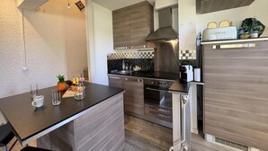 A modern kitchen with a central island, stainless steel appliances, and a checkered backsplash.