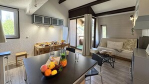 A modern kitchen with a central island, dining area, and a cozy living space with a sofa and a coffee table.