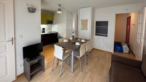 A compact living space with a dining area, kitchenette, and a television. - 350m from ski slopes, 3rd floor, view ski slopes, balcony, 33m², Serre Chevalier (Saint-Chaffrey)