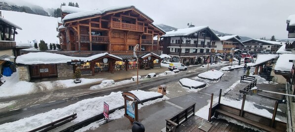 A snowy mountain village with wooden buildings, a ski lift, and a sign for 'Sport 2000'.