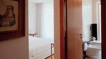 Un dormitorio con cama, mesita de noche y baño completo.