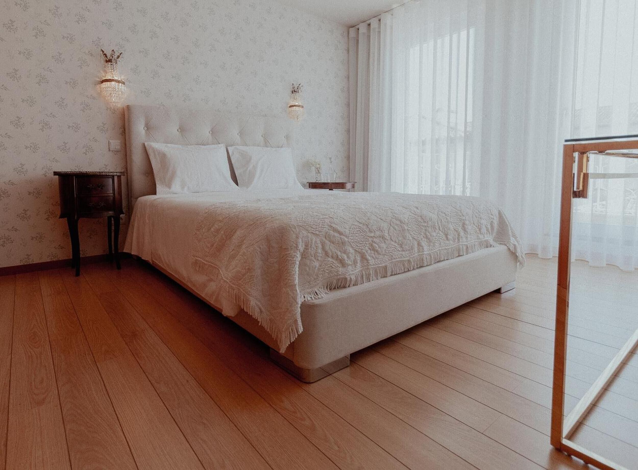 Une chambre à coucher avec un lit, des tables de chevet et une fenêtre avec des rideaux.