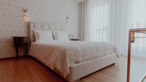 A bedroom with a bed, nightstands, and a window with curtains.