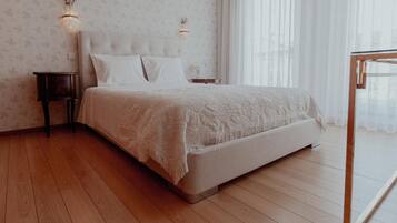 Une chambre à coucher avec un lit, des tables de chevet et une fenêtre avec des rideaux.