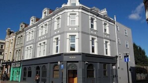 Un edificio storico con un ingresso d'angolo, ampie finestre e una numerazione ben visibile.