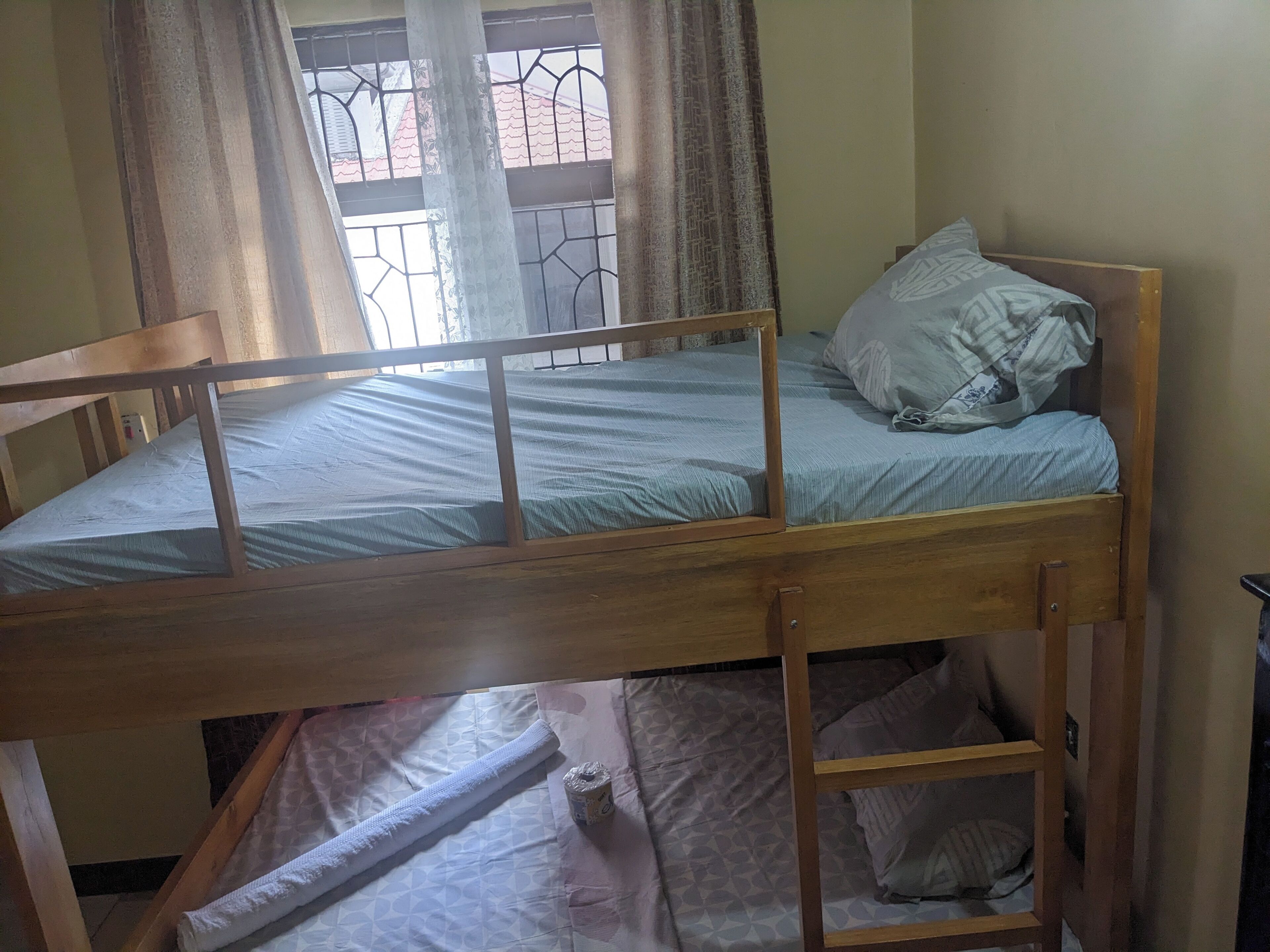 Una cama litera con estructura de madera, un colchón individual y una almohada.
