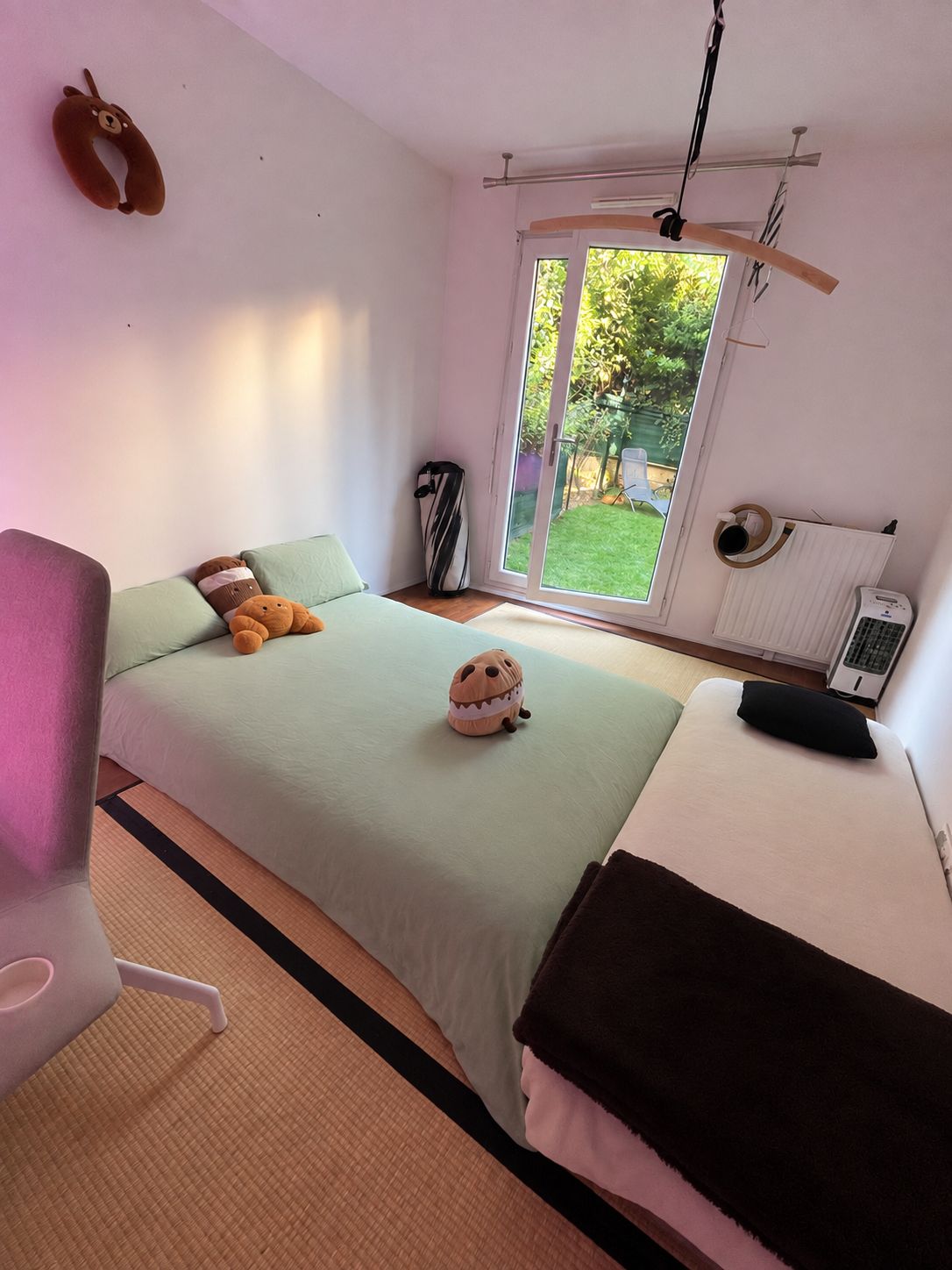 Une chambre à coucher comprenant un lit, une chaise, un radiateur et une fenêtre donnant sur un paysage verdoyant.
