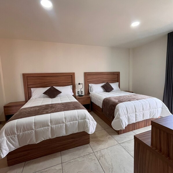 A hotel room with two beds, each with wooden headboards and white bedding. - Quinta Candela Hotel (Chignahuapan)