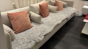 Un soggiorno moderno con un divano, una coperta soffice e una televisione.