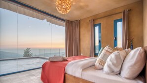 A bedroom with a large bed, a view of the sky, and a balcony. - Red Oak House With Garden & Terrace in Assia, Batroun (Bchaaleh)