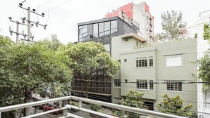 Ein mehrstöckiges Gebäude mit modernem Design, große Fenster und ein flaches Dach.